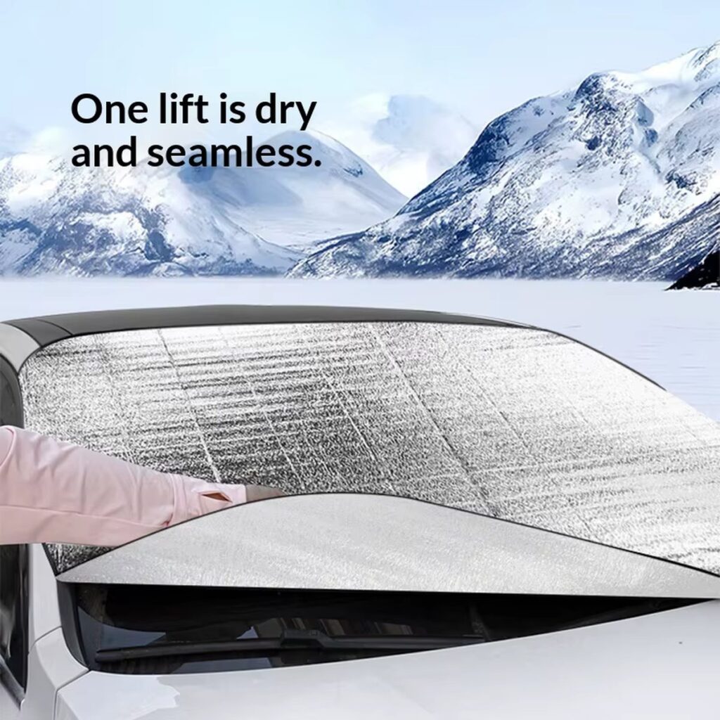 Hand lifting a windshield snow cover off a car