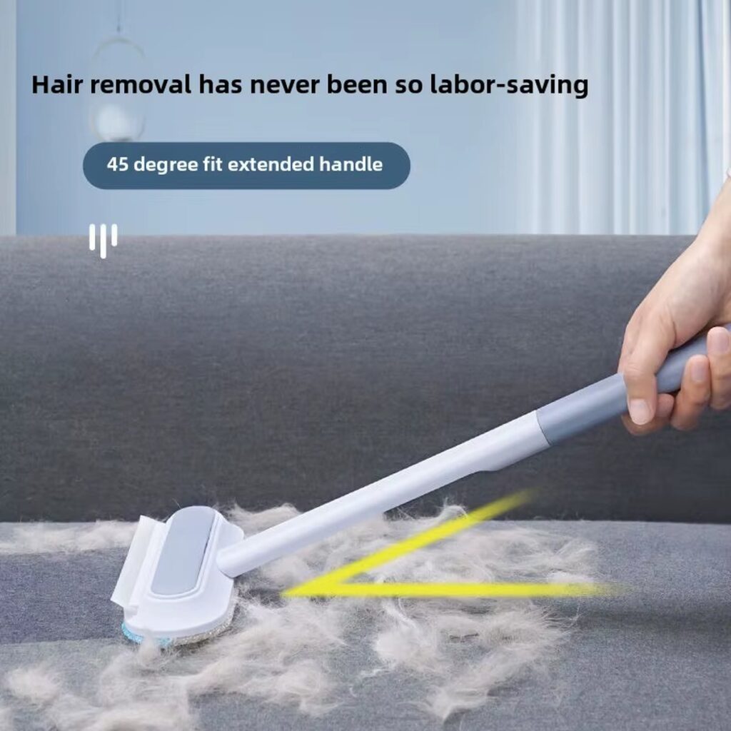 Long-handle brush lifting pet hair from a sofa